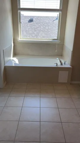 a bathroom with a bathtub and window