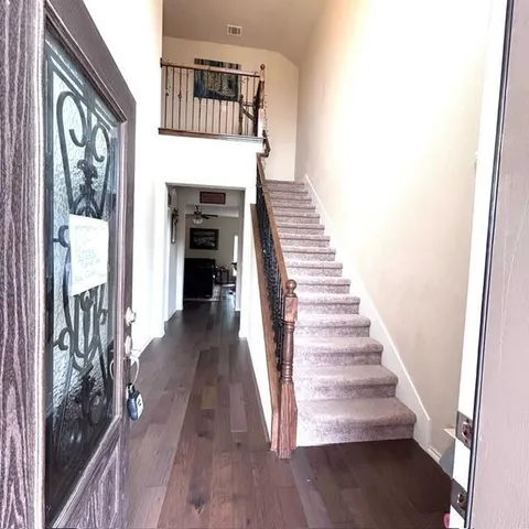 a view of a hallway with wooden floor and staircase