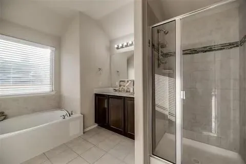 a bathroom with a tub shower and sink