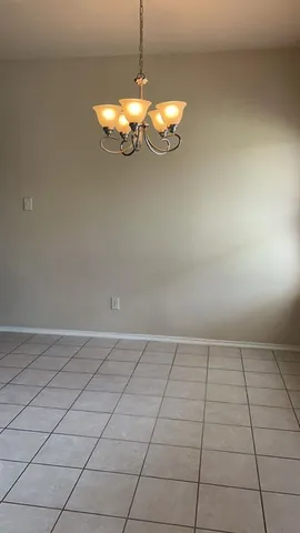 an empty room with a chandelier fan