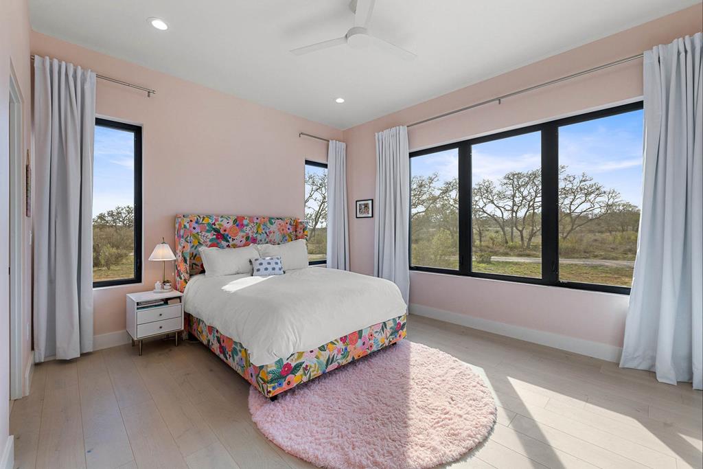 444 Klein Road Stonewall, TX 78671 - Photo 22 of 55 a bed room with a bed and a large window