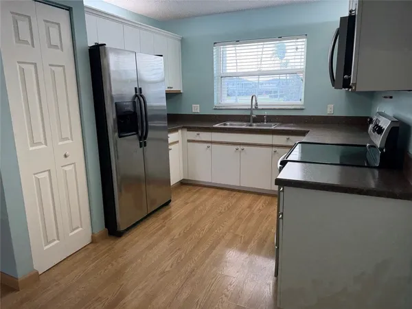 a kitchen with stainless steel appliances granite countertop a refrigerator and a sink