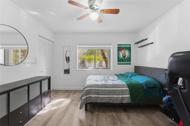 a bedroom with a bed a mirror and a window