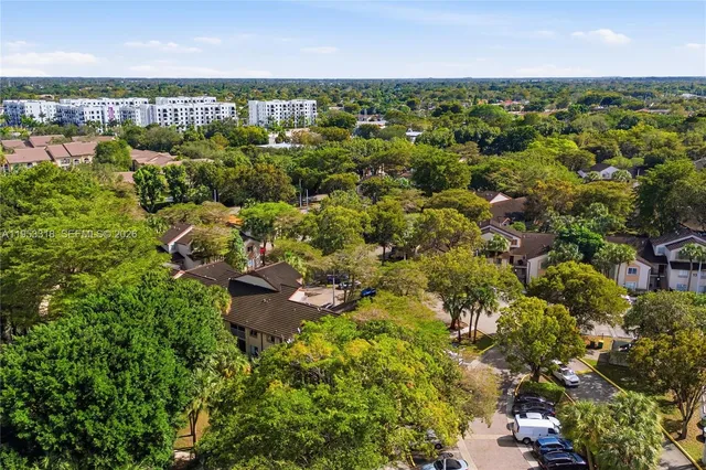 an aerial view of residential houses with outdoor space and trees