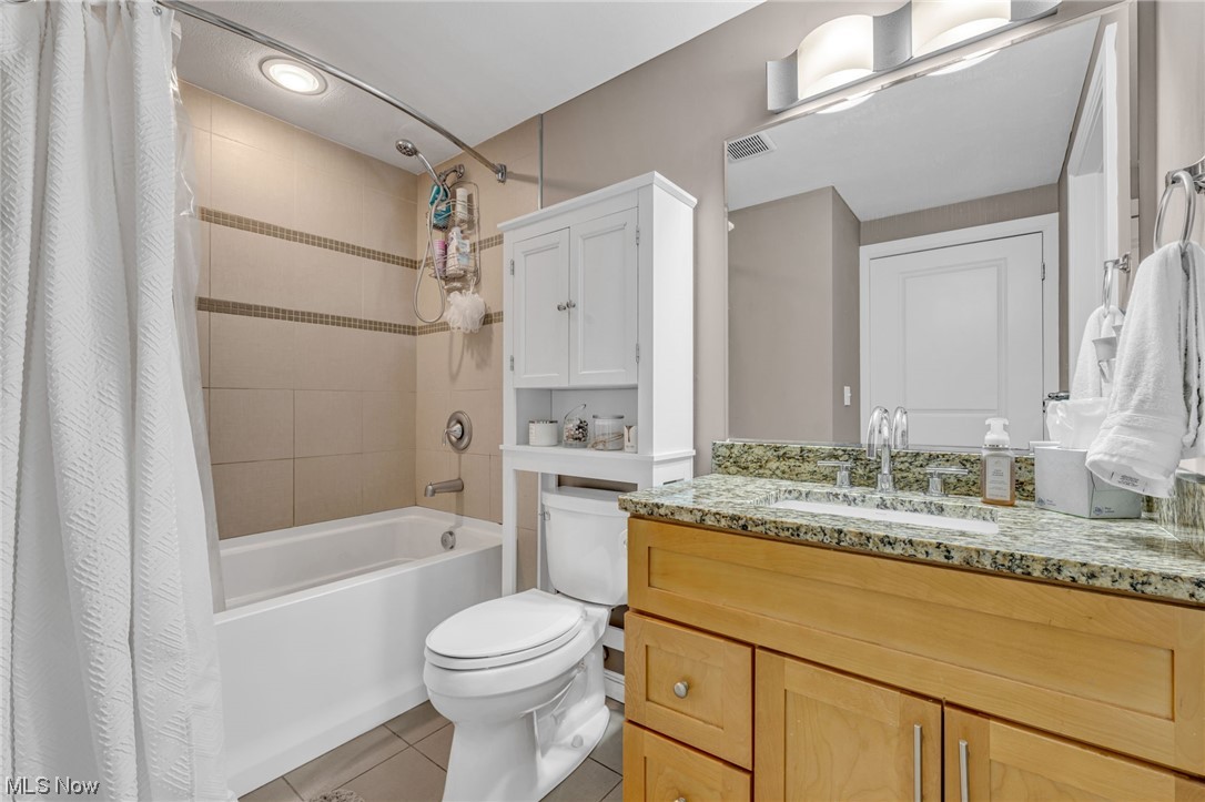 1237 Washington Avenue, Unit 1110 Cleveland, OH 44113 - Photo 18 of 28 Full bathroom featuring shower / bath combo with shower curtain, mirror, light tile floors, and vanity