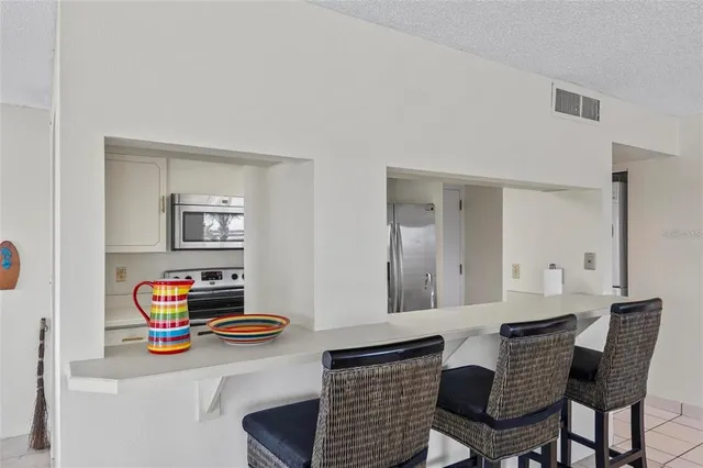 a living room with furniture and a dining table with bookshelf