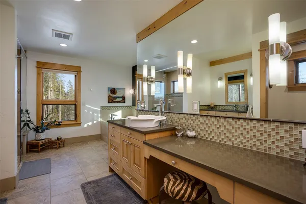 a bathroom with a granite countertop sink a mirror and a bathtub
