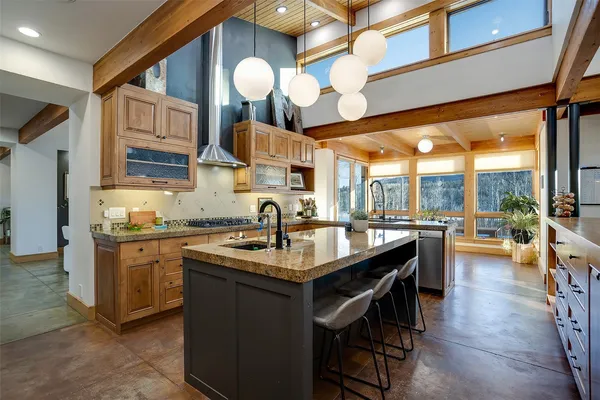 a kitchen with stainless steel appliances granite countertop a sink a stove and a wooden floors