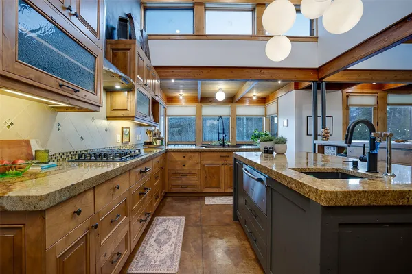 a large kitchen with stainless steel appliances granite countertop a sink and cabinets