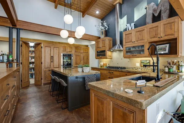 a kitchen with stainless steel appliances granite countertop a sink a stove and a wooden cabinets