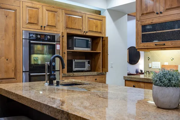 a kitchen view of a kitchen island a sink stainless steel appliances and cabinets