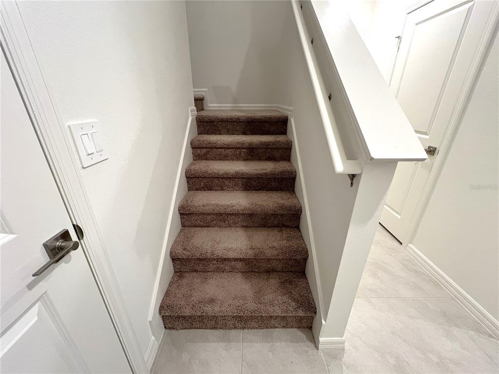 758 Stoney Point Circle Davenport, FL 33896 - Photo 23 of 42 a view of staircase with white walls and a window