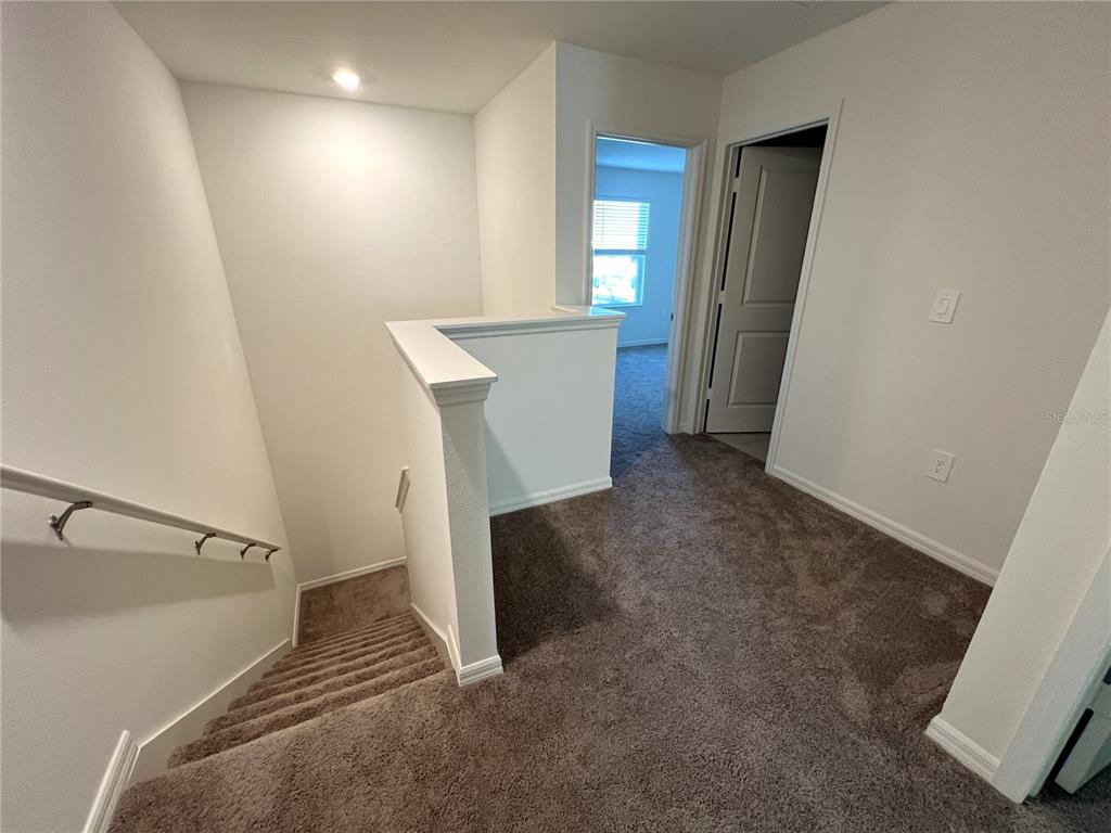758 Stoney Point Circle Davenport, FL 33896 - Photo 26 of 42 a view of hallway with stairs and a window