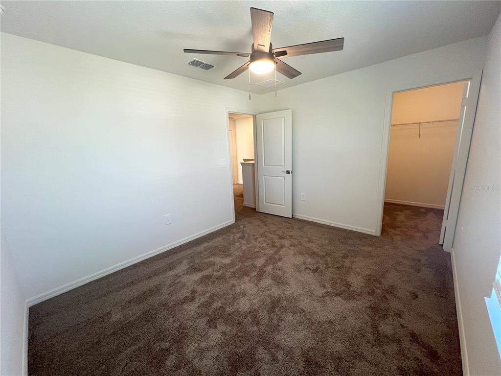758 Stoney Point Circle Davenport, FL 33896 - Photo 30 of 42 en empty room with windows and fan