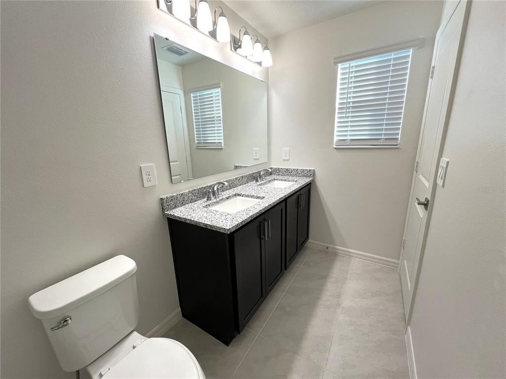 758 Stoney Point Circle Davenport, FL 33896 - Photo 39 of 42 a bathroom with a sink vanity mirror and toilet