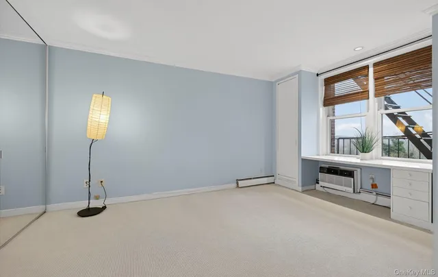 a view of an empty room with a window and fireplace