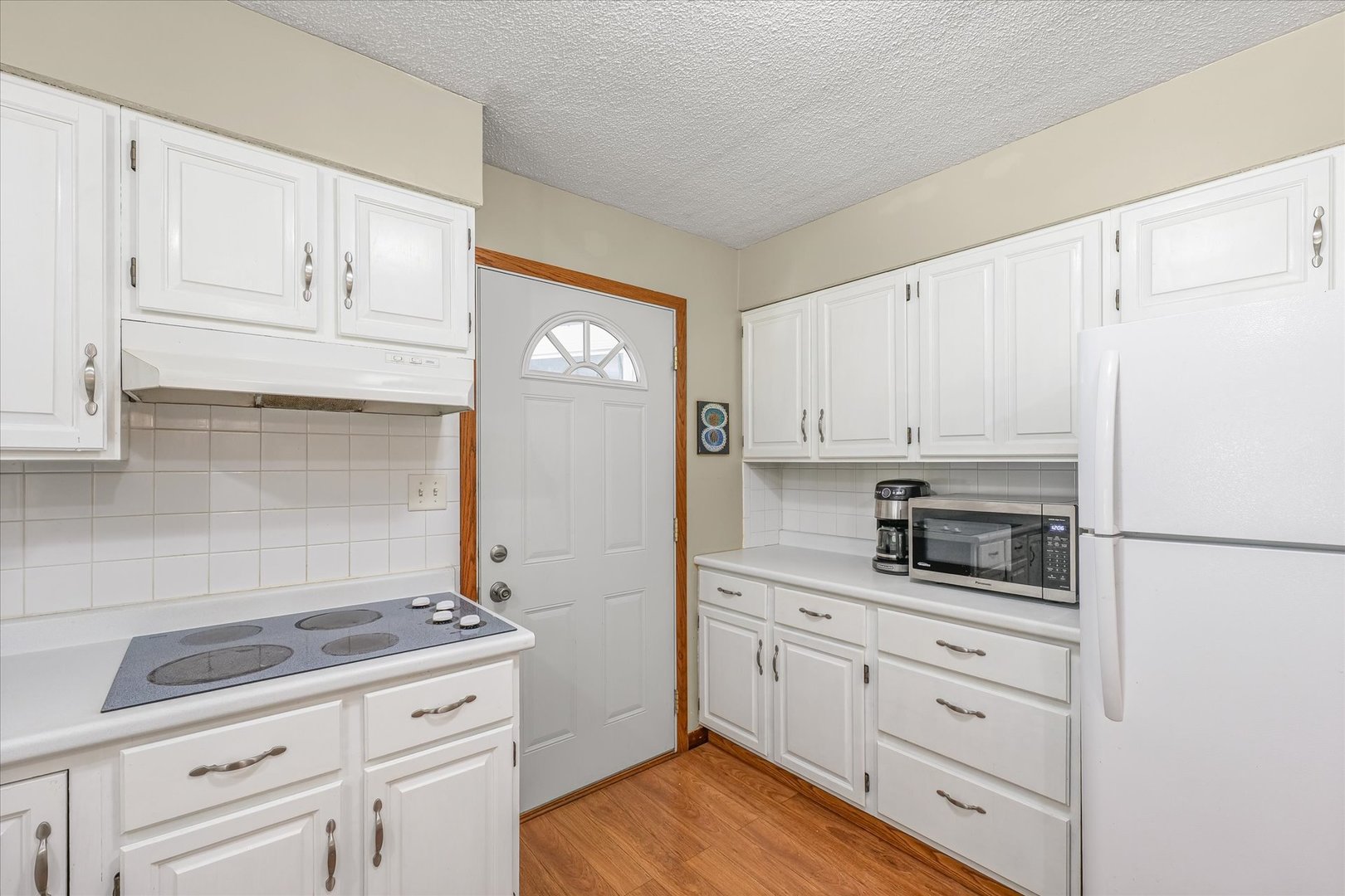 9835 East 1610 North Road Oakwood, IL 61858 - Photo 11 of 35 a kitchen with white cabinets and appliances