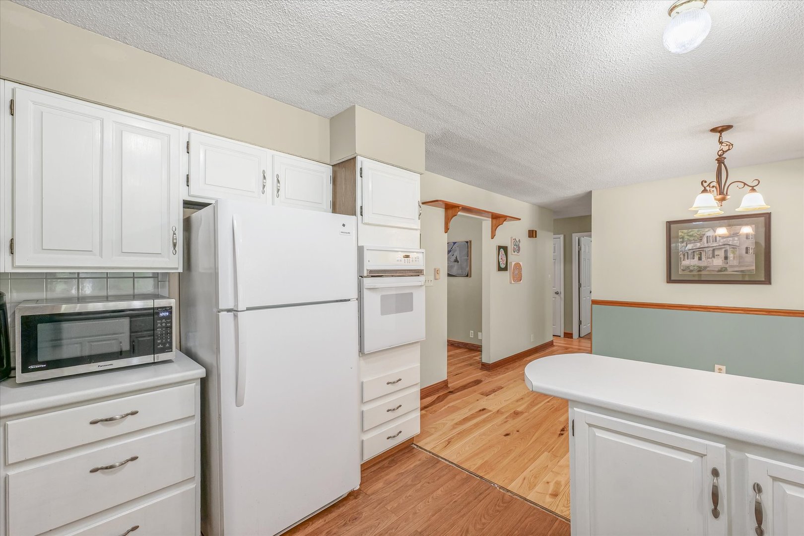 9835 East 1610 North Road Oakwood, IL 61858 - Photo 12 of 35 a white refrigerator freezer sitting in a kitchen with white cabinets