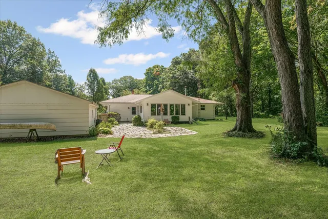 a view of a house with backyard and sitting area