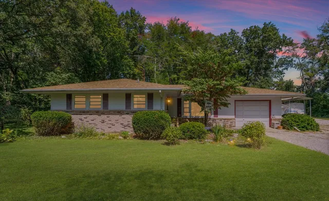 a front view of a house with a yard and trees