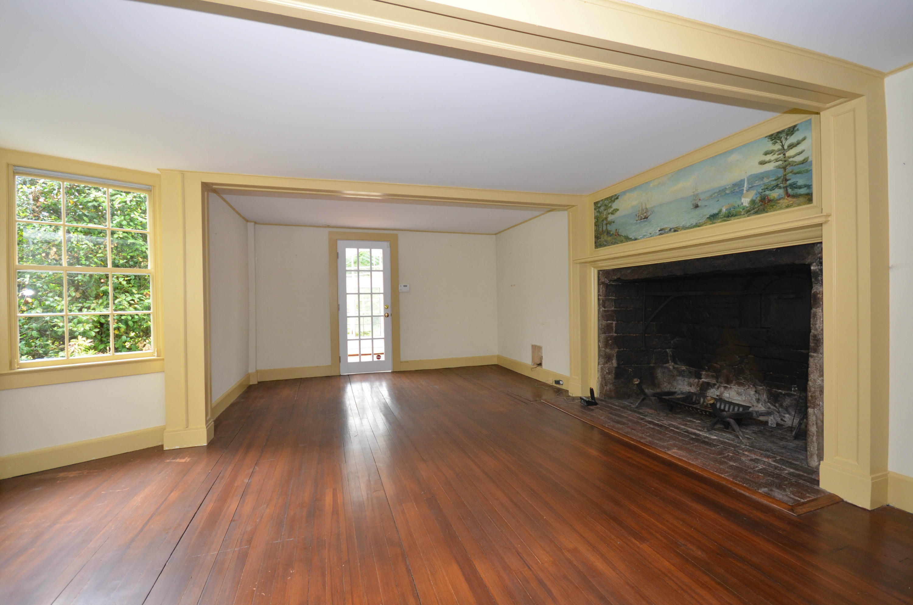 1462 Oenoke Ridge New Canaan, CT 06840 - Photo 12 of 25 a view of an empty room with wooden floor fireplace and a window