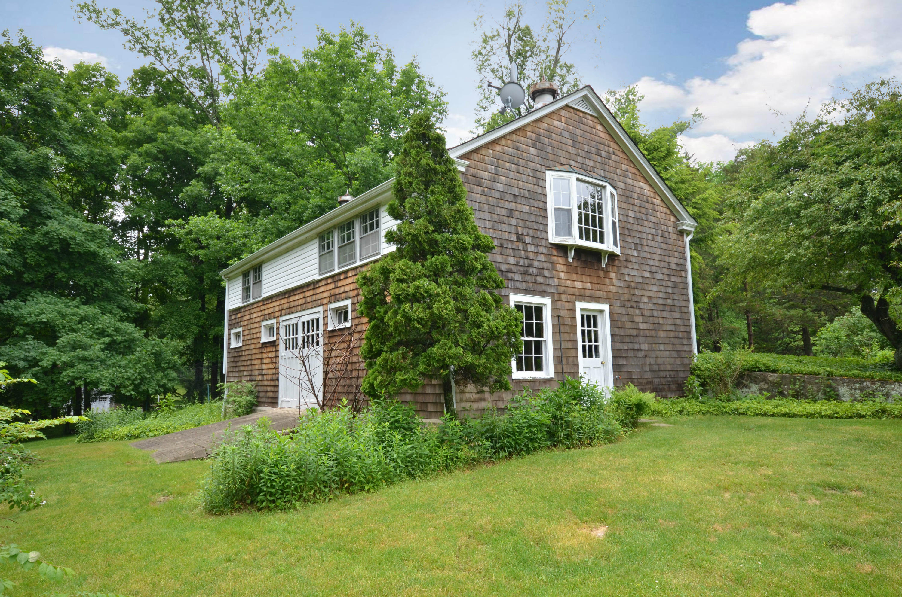 1462 Oenoke Ridge New Canaan, CT 06840 - Photo 18 of 25 a front view of a house with garden