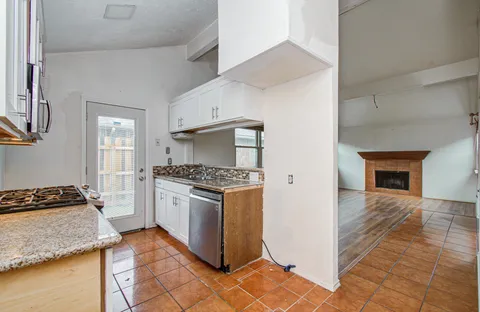 a kitchen with granite countertop a stove and a refrigerator