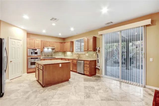 a kitchen with stainless steel appliances granite countertop a refrigerator oven a sink and dishwasher