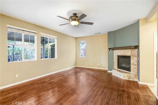 a view of an empty room with a fireplace and a window
