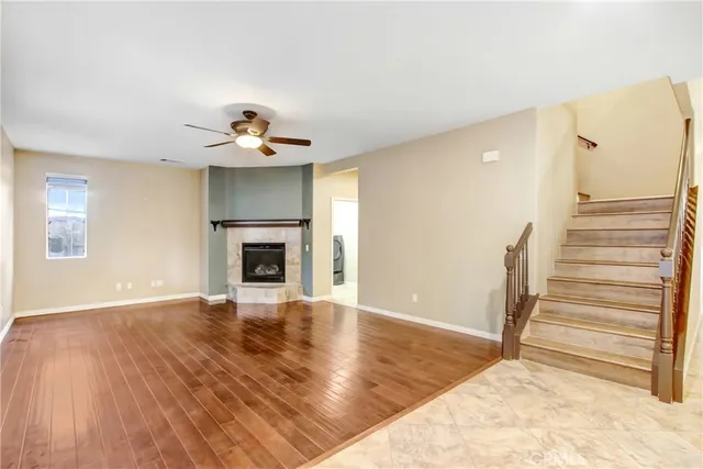 a view of a livingroom with wooden floor and a ceiling fan