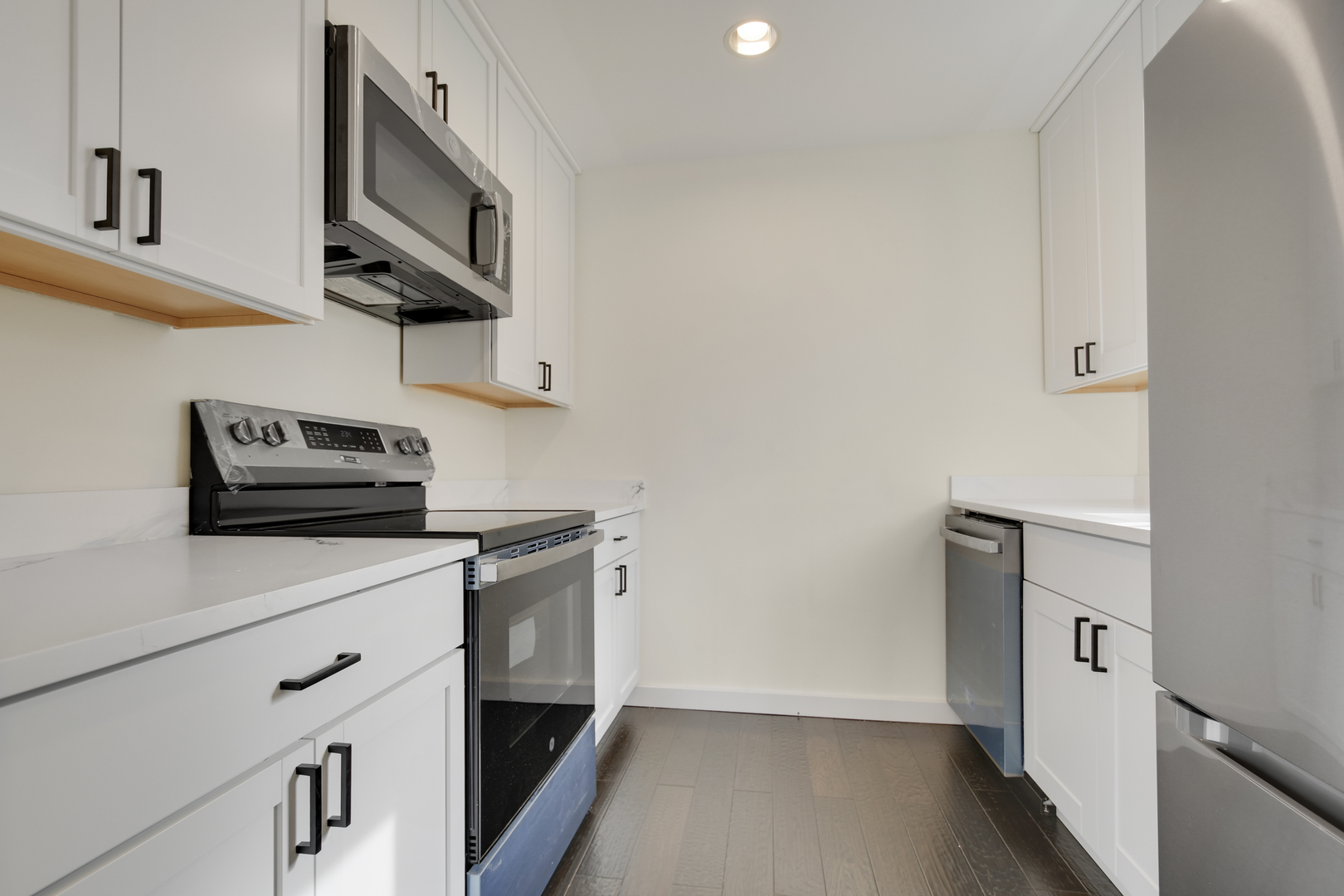 491 Old Surrey Road, Unit B Hinsdale, IL 60521 - Photo 14 of 29 a kitchen with stainless steel appliances a sink a stove a microwave and cabinets
