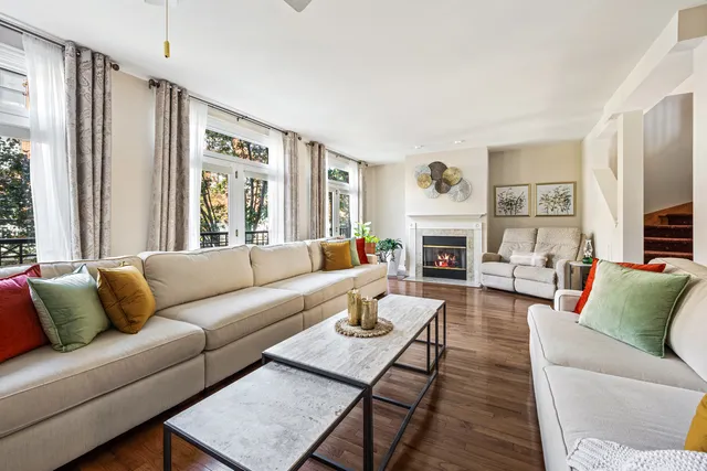 a living room with furniture fireplace and a large window