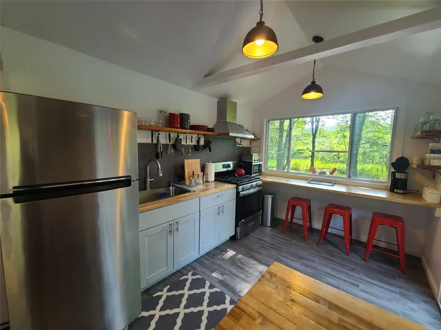 a kitchen with stainless steel appliances granite countertop a refrigerator and a stove