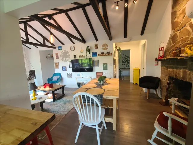 a dining room with furniture a fireplace and wooden floor