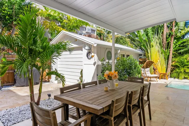 a backyard of a house with table and chairs