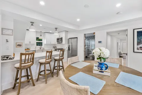 a room with stainless steel appliances kitchen island granite countertop furniture and a dining table