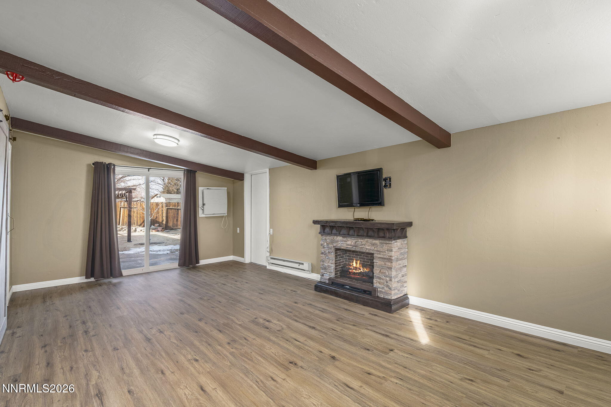 11303 Rocky Mountain Street Reno, NV 89506 - Photo 14 of 28 a view of empty room with wooden floor and fireplace