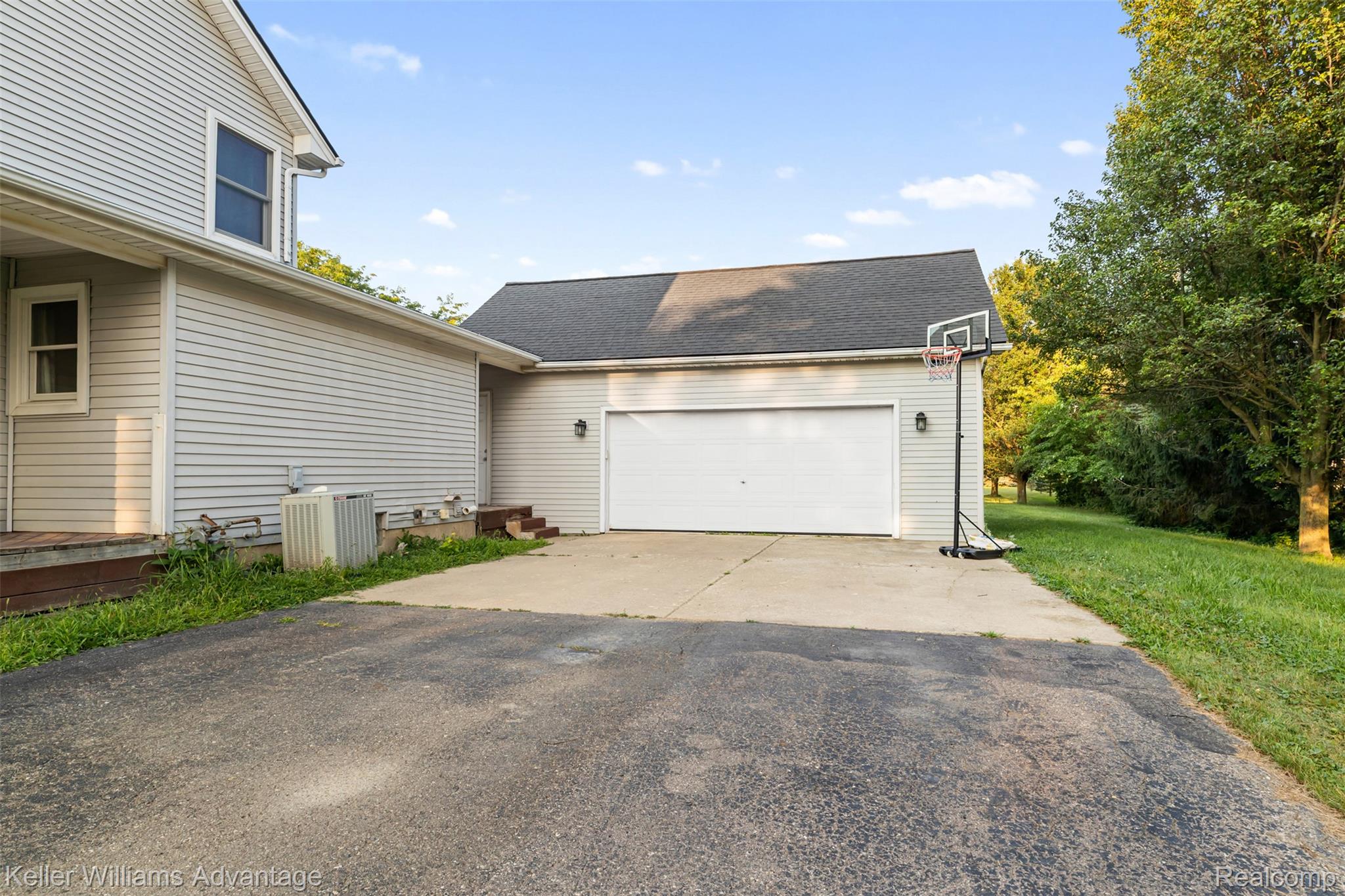 22627 Otter Road New Boston, MI 48164 - Photo 3 of 52 Attached garage featuring a white overhead door and exterior lighting