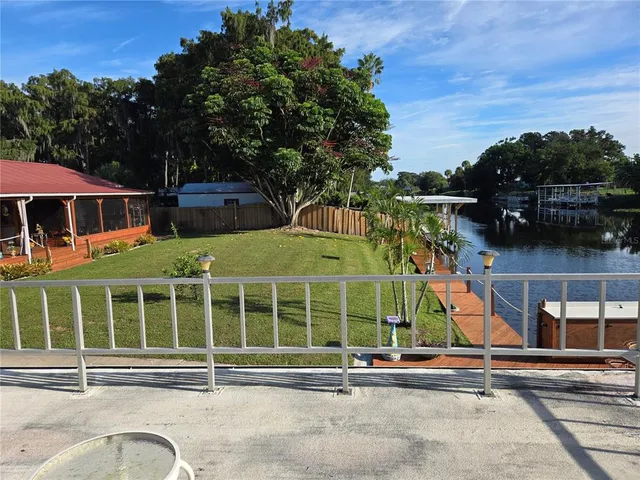 a view of a brick house with a big yard and large trees
