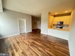 a view of a kitchen with kitchen island a stove a wooden floor and a sink