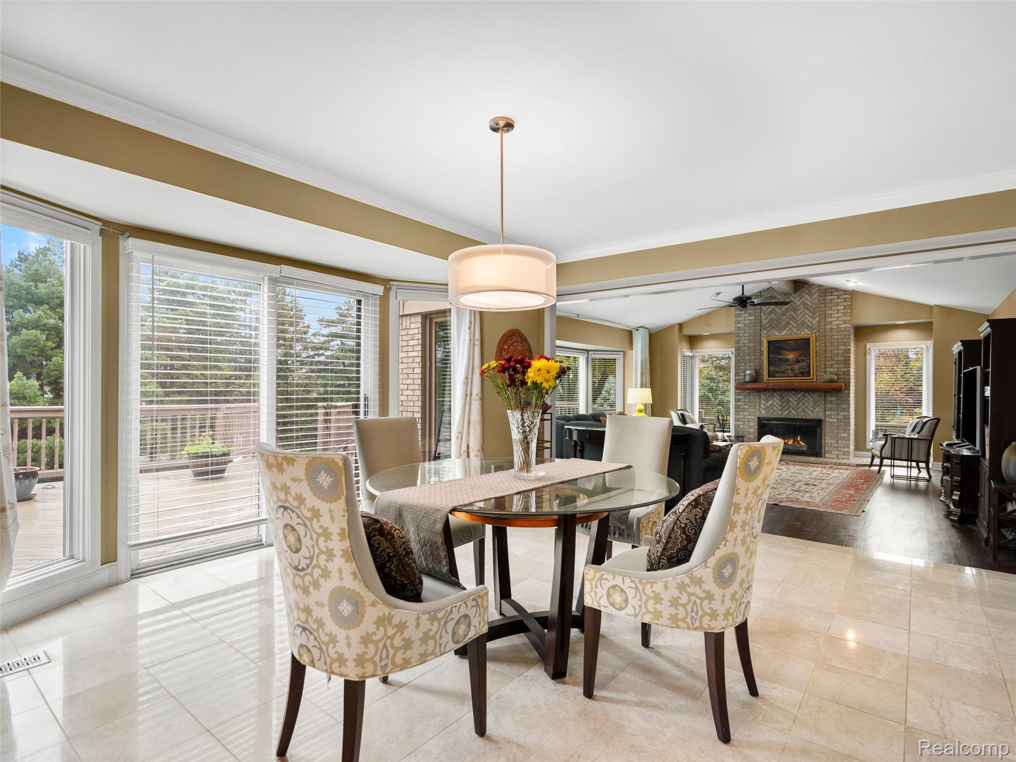 5724 Murfield Drive Rochester, MI 48306 - Photo 53 of 99 Dining space with a brick fireplace, ornamental molding, vaulted ceiling, light tile patterned floors, and ceiling fan