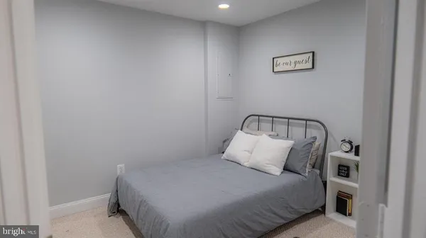 a bedroom with a bed and a lamp on dresser