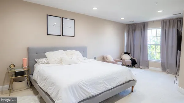 a bedroom with a bed and a large mirror