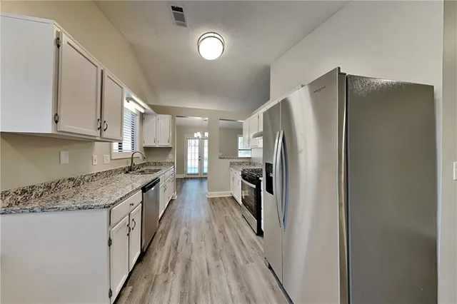 a kitchen with stainless steel appliances granite countertop a refrigerator and a stove