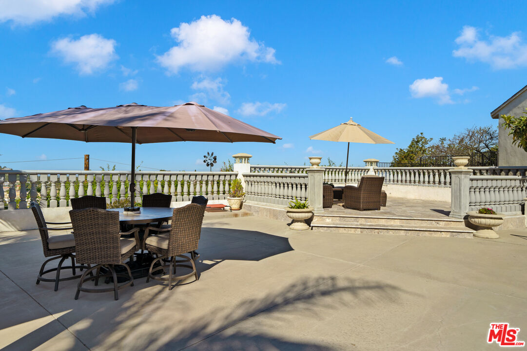 5437 Middlecrest Road Rancho Palos Verdes, CA 90275 - Photo 26 of 32 a view of a patio with a table and chairs under an umbrella