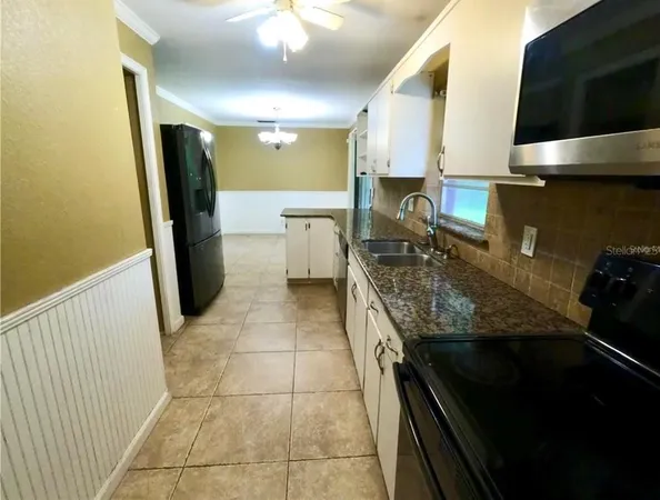 a kitchen with a sink appliances and cabinets