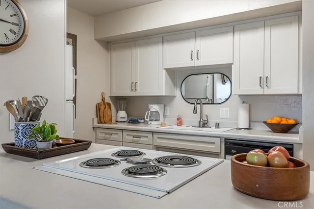 a kitchen with a stove a sink and cabinets