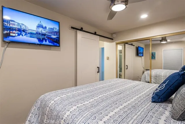 a bedroom with a large bed and a chandelier