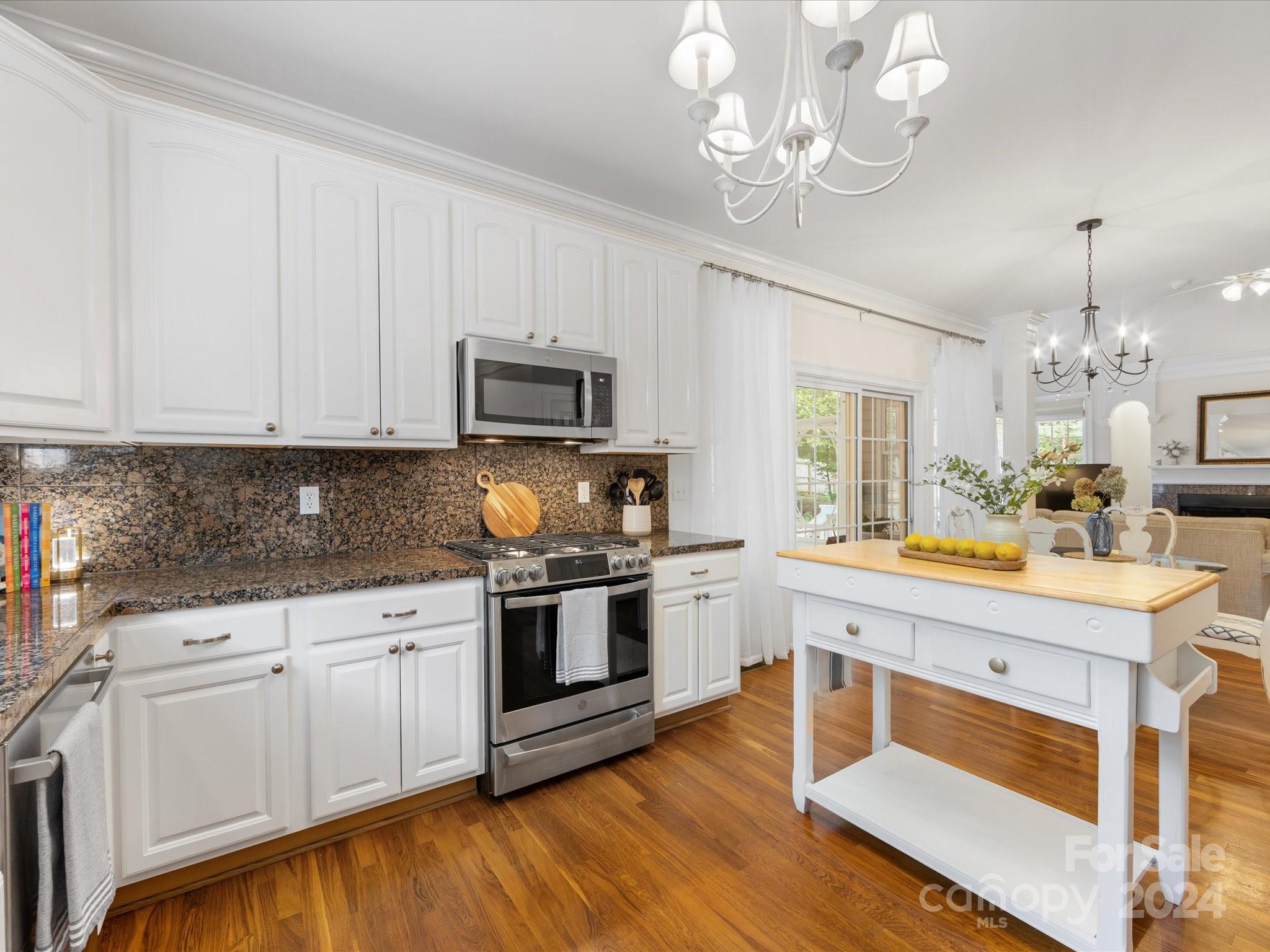 4100 Cherrybrook Drive Mint Hill, NC 28227 - Photo 14 of 45 a kitchen with stainless steel appliances granite countertop a stove top oven a sink dishwasher and a microwave oven on the blue kitchen countertops with wooden floor