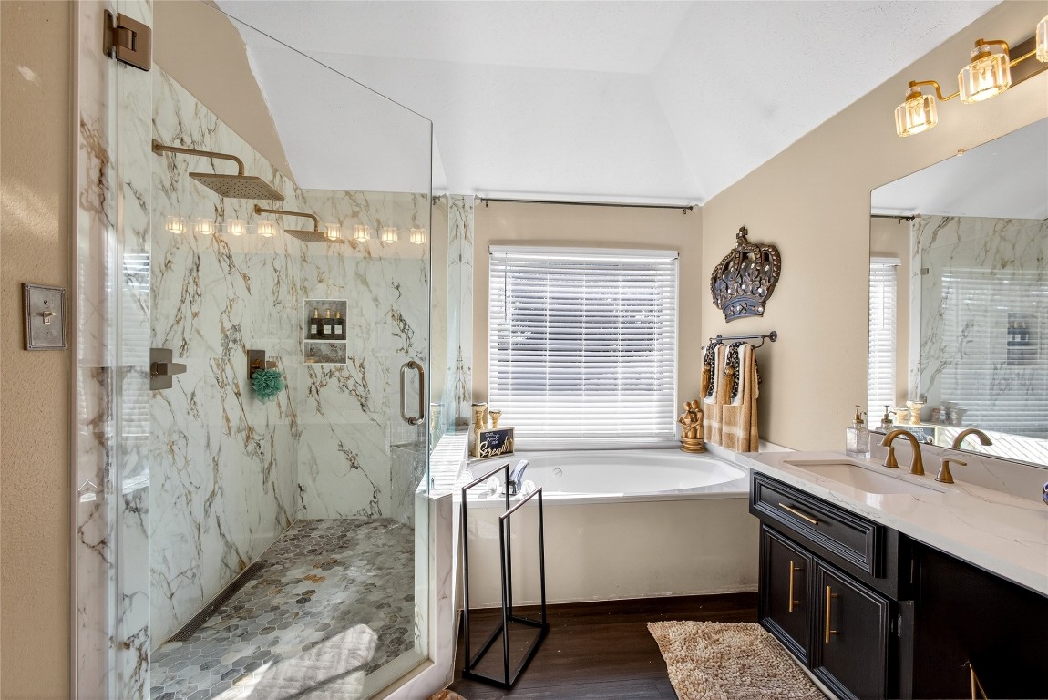 a bathroom with a sink a toilet a mirror and shower